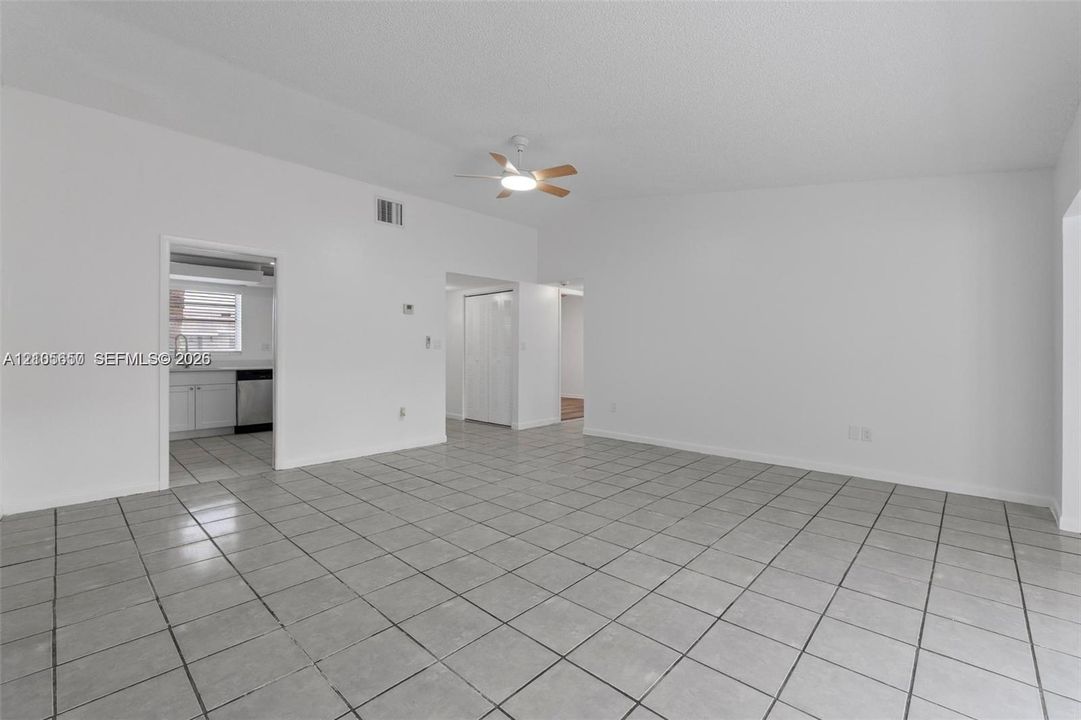 Open-concept interior space featuring ceramic tile flooring, vaulted ceilings, and a central ceiling fan
