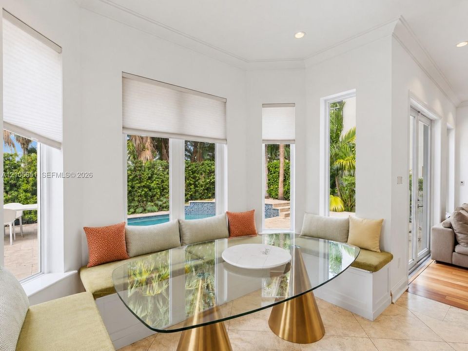 Bay window featuring built-in bench seating, recessed lighting, crown molding, and large-format tile flooring