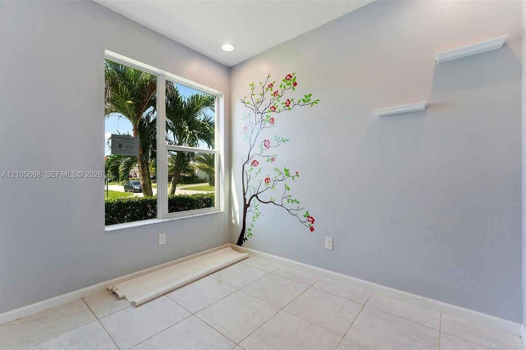 Neutral wall palette featuring a single-pane window, tile flooring, recessed ceiling lighting, and two mounted floating shelves