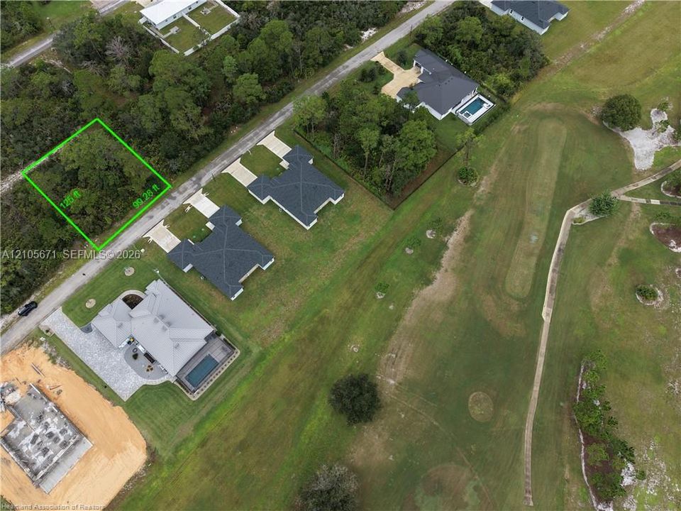 Vacant parcel featuring 125-foot by 99-foot lot dimensions with mature trees and direct access to paved road frontage