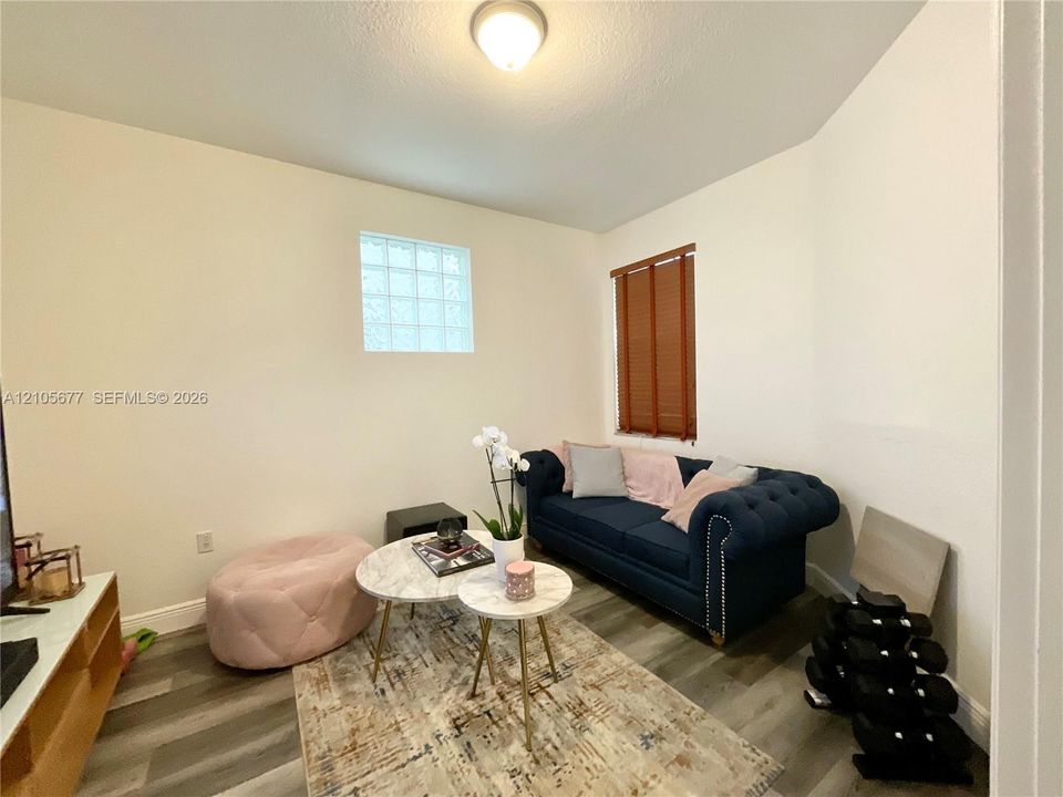 Wood-finish flooring, glass block window, and flush-mount ceiling lighting