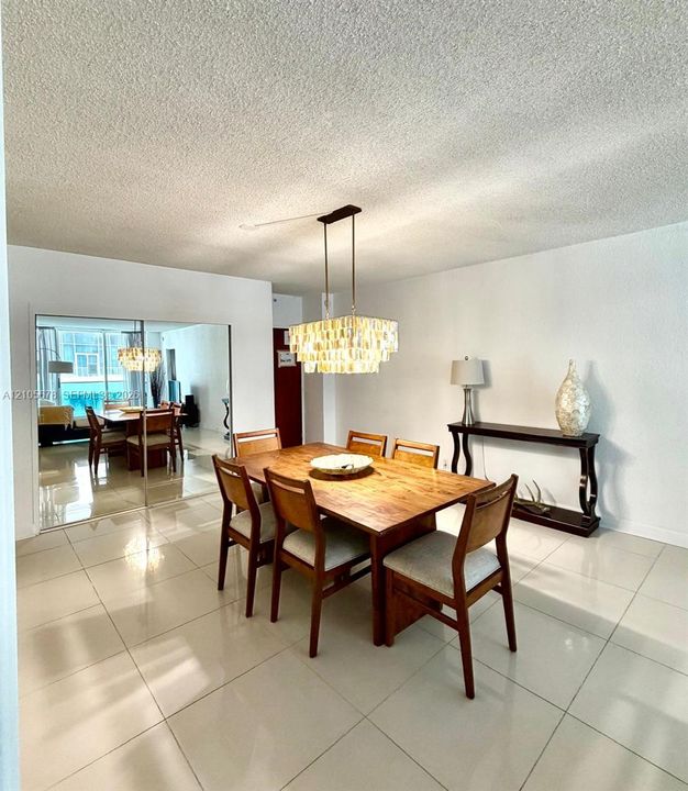 Large-format tile flooring, tiered crystal chandelier, and floor-to-ceiling mirrored closet doors