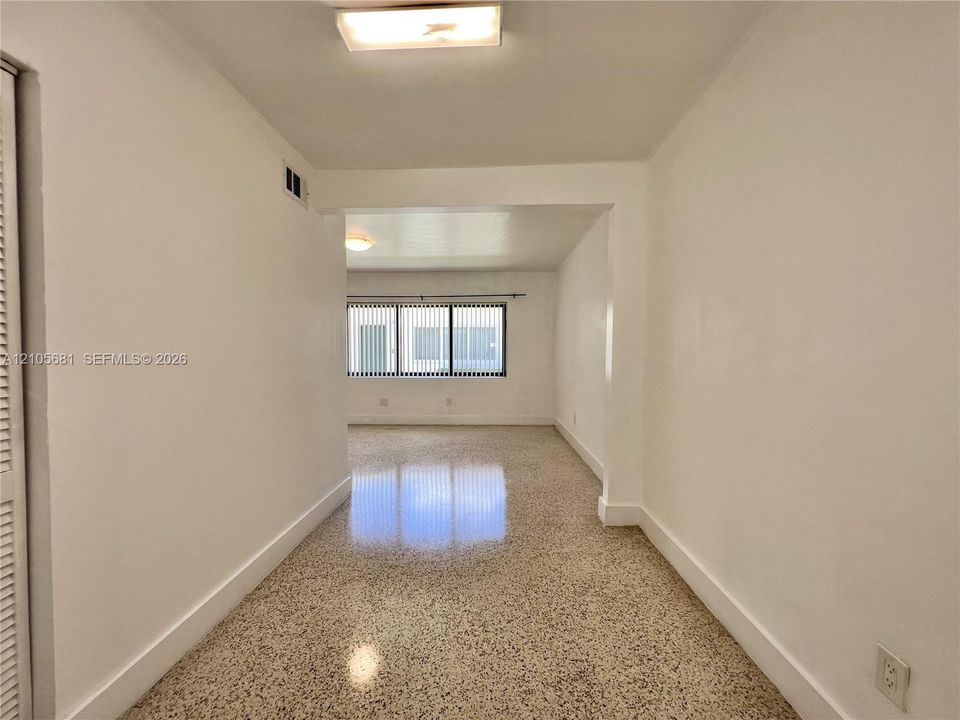 Interior space featuring polished terrazzo flooring, horizontal blinds, and a flush-mount ceiling light fixture