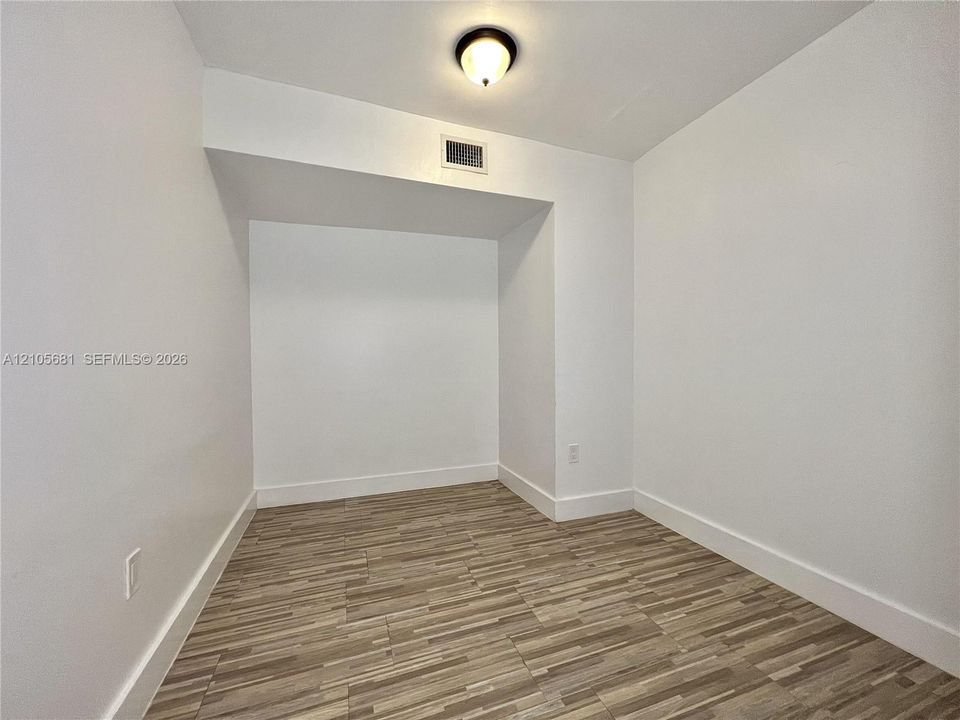 Interior space featuring wood-finish flooring, a recessed alcove, and a flush-mount dome light fixture