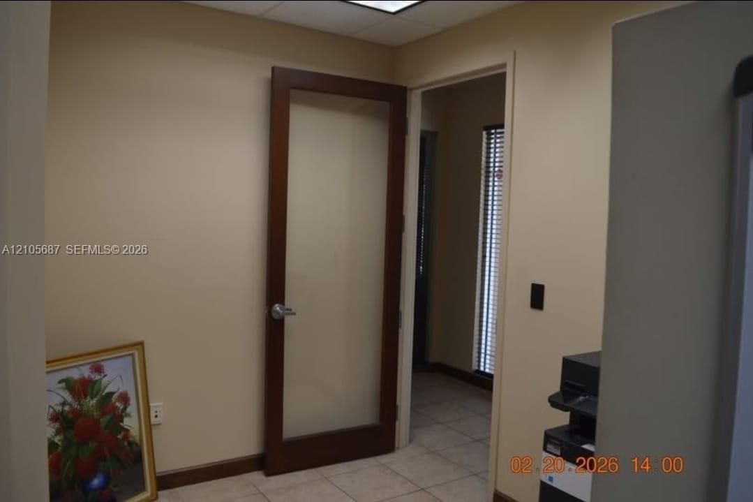 Solid wood-frame door featuring a full-length frosted glass panel, neutral interior wall tones, and ceramic tile flooring