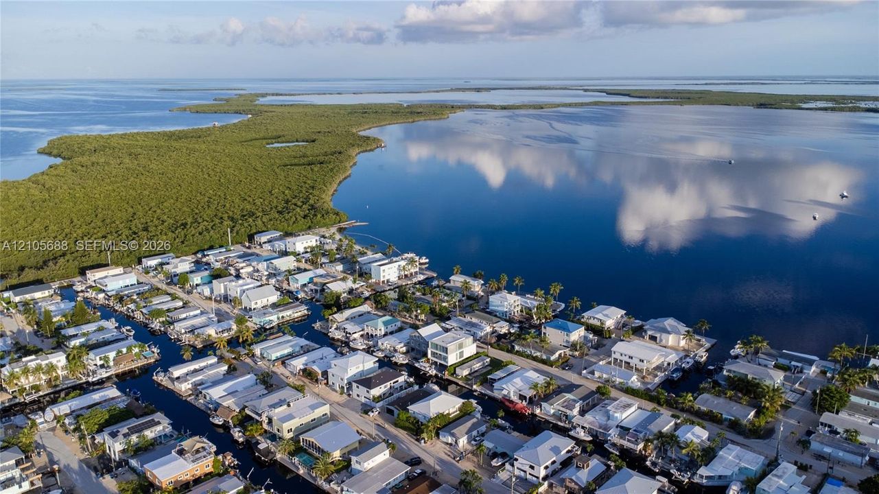 Aerial perspective of waterfront properties featuring deep-water canal access and proximity to open water