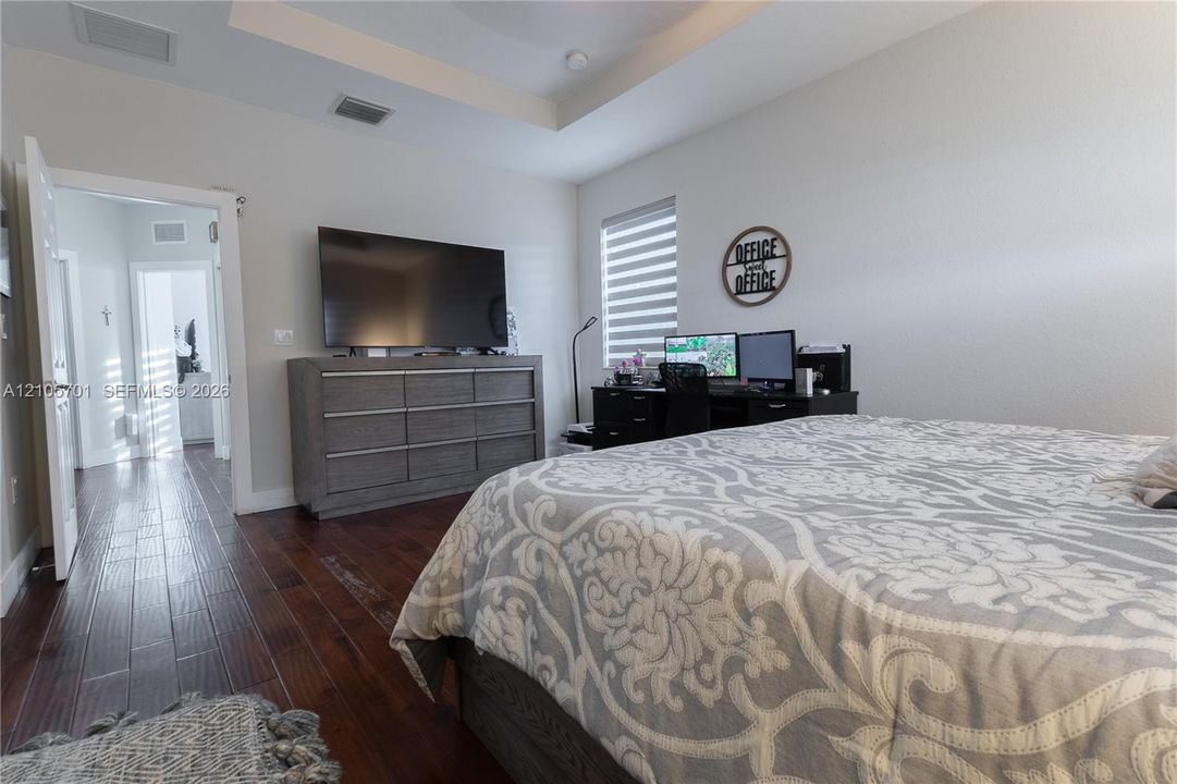 Tray ceiling, wood-finish flooring, and window with adjustable blinds