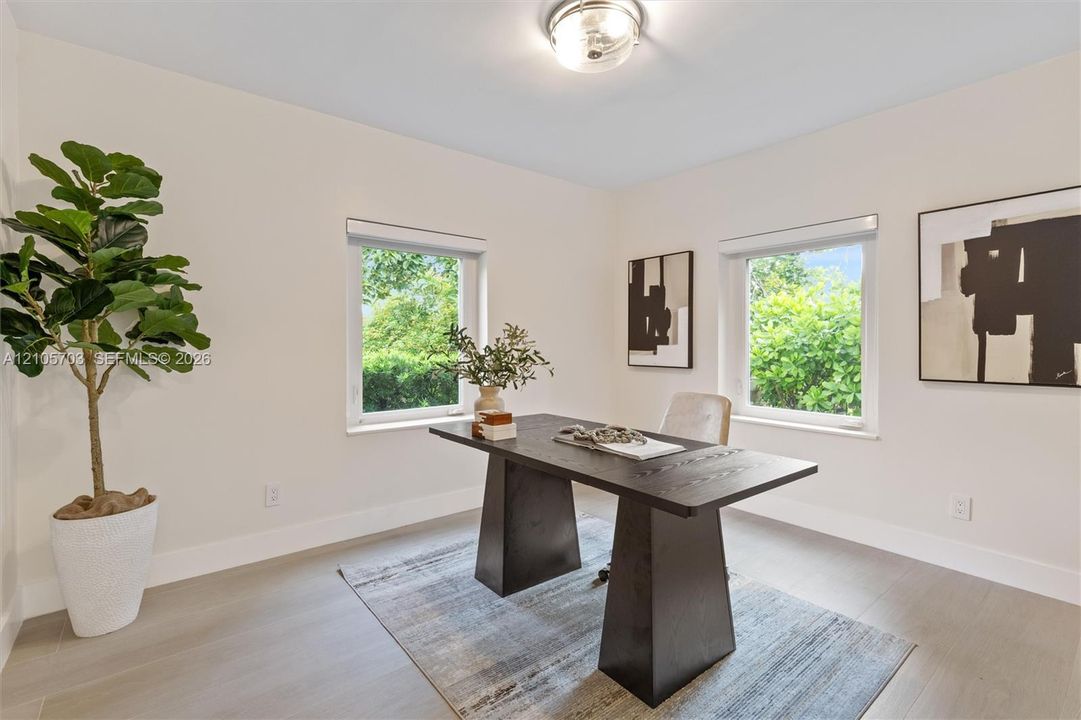 Neutral-toned interior space featuring light-colored flooring, two dual-pane windows, and a flush-mount ceiling fixture