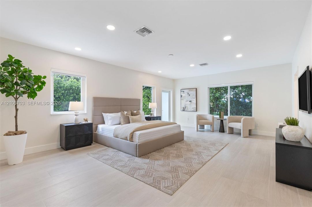 Spacious room featuring wood-finish flooring, recessed lighting, and multiple windows providing natural light
