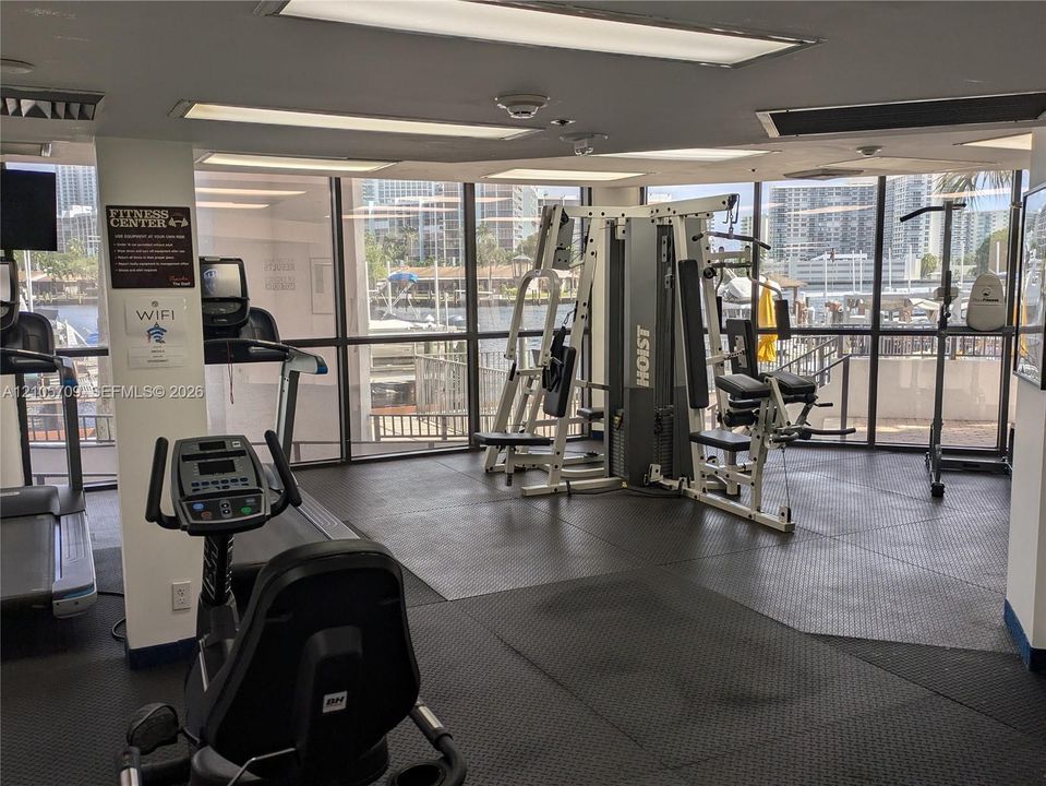 Fitness center featuring floor-to-ceiling windows, rubberized flooring, and recessed ceiling lighting