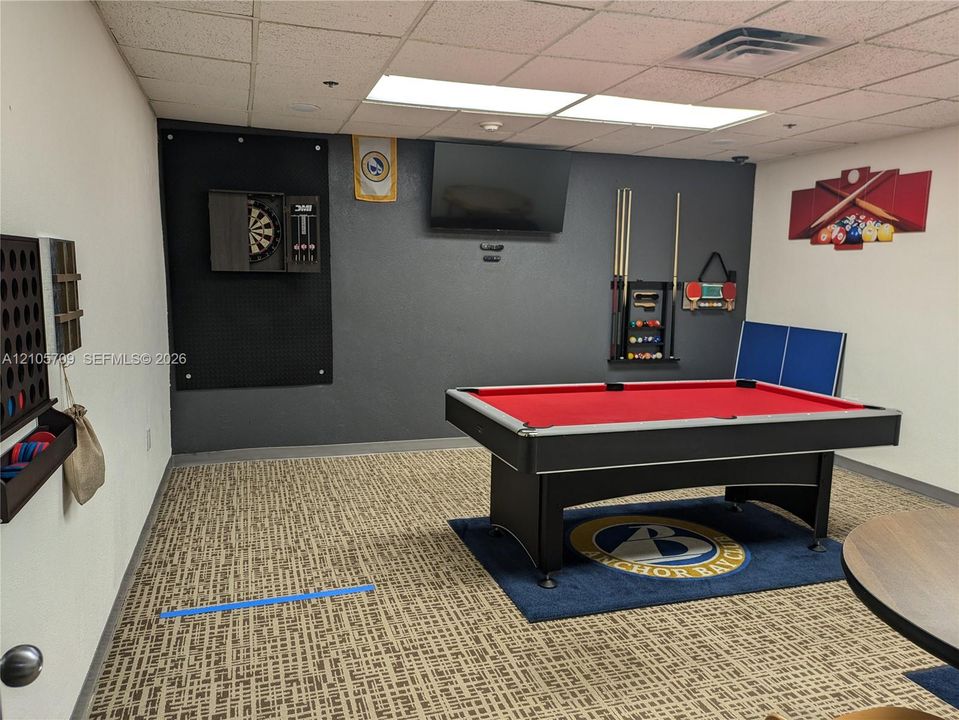 Finished flex space featuring a patterned carpet floor, neutral wall paint, and a drop ceiling with recessed lighting
