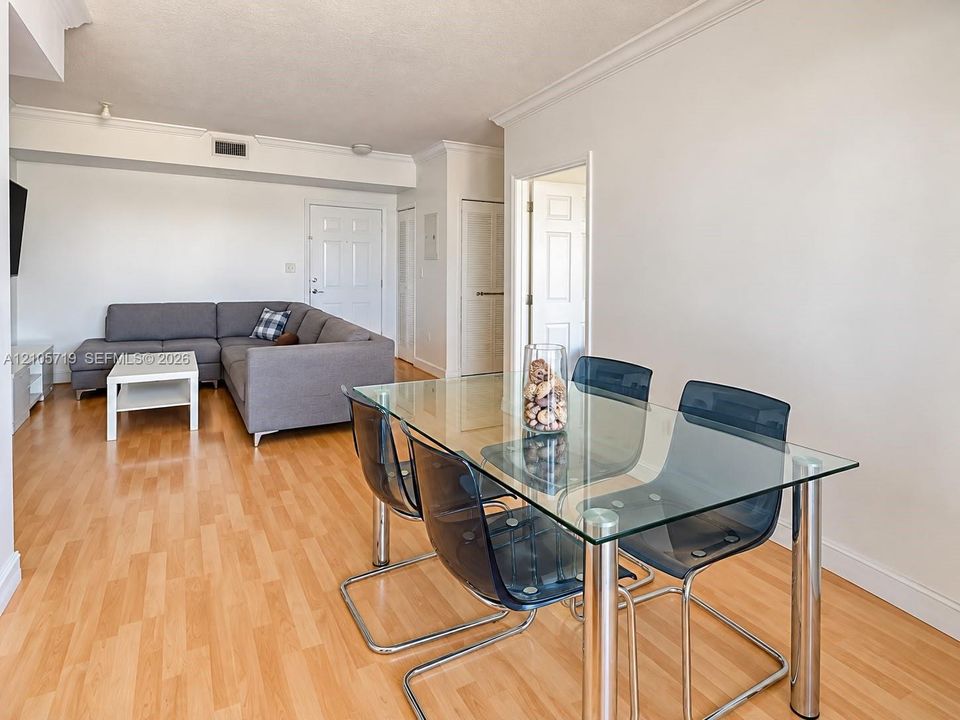Interior space featuring wood-finish flooring, crown molding, six-panel interior doors, and a neutral color palette