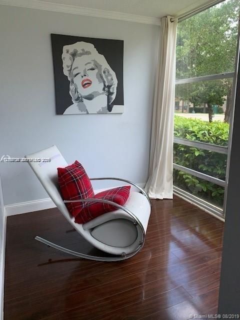 Floor-to-ceiling windows featuring horizontal frames, wood-finish flooring, and crown molding