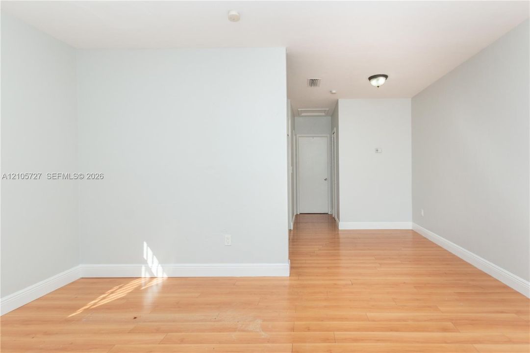 Neutral-toned interior walls featuring wood-finish flooring and a flush-mount ceiling light fixture