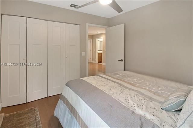 Room featuring neutral-toned walls, wood-finish flooring, a multi-panel closet with integrated doors, and a ceiling-mounted light fixture