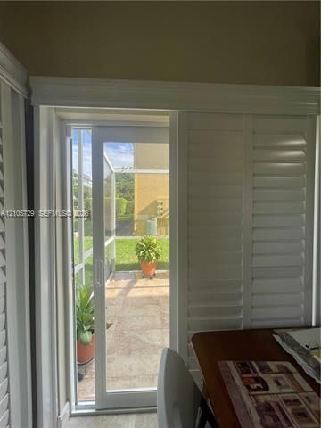Sliding glass door featuring white plantation shutters and heavy-duty decorative trim framing