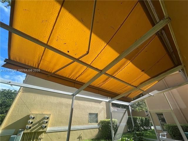Retractable yellow awning featuring a metal frame and screen-enclosed outdoor space