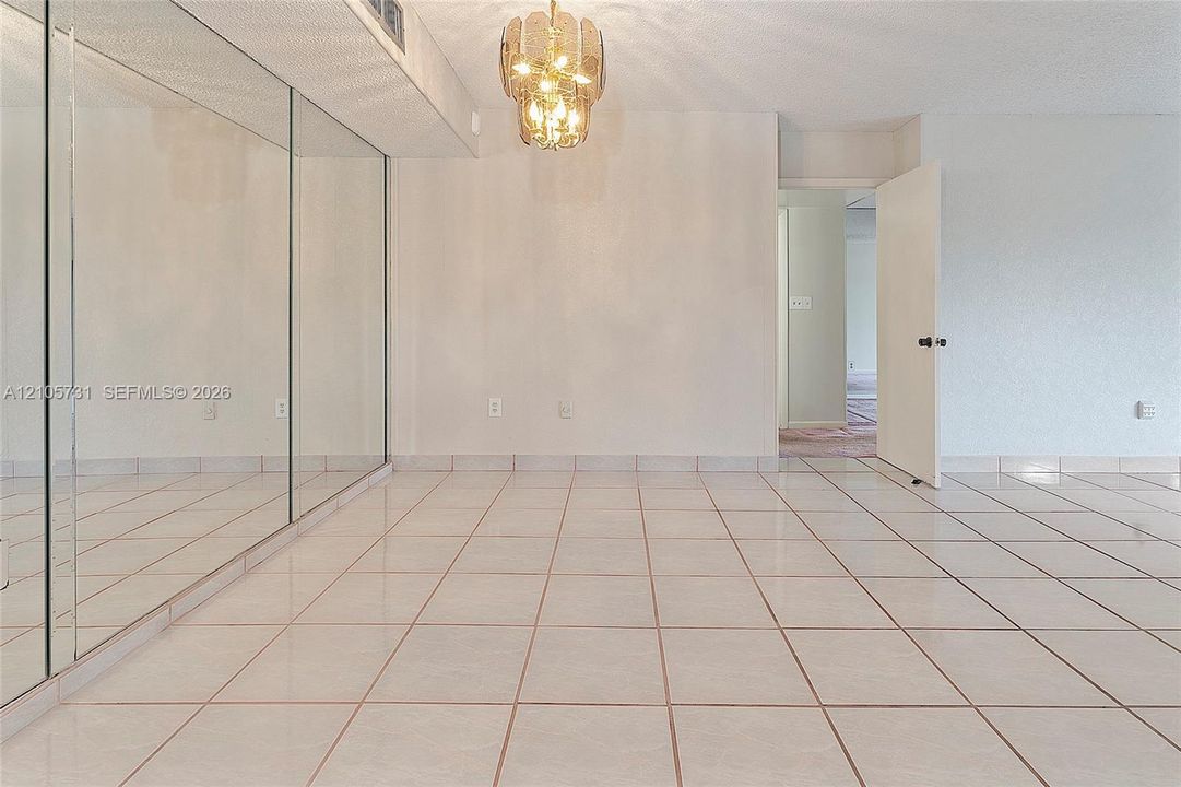 Ceramic tile flooring, full-wall mirrors, and a decorative tiered chandelier