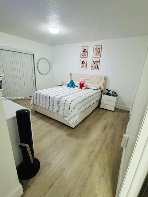 Wood-finish flooring, flush-mount ceiling lighting, and sliding closet doors