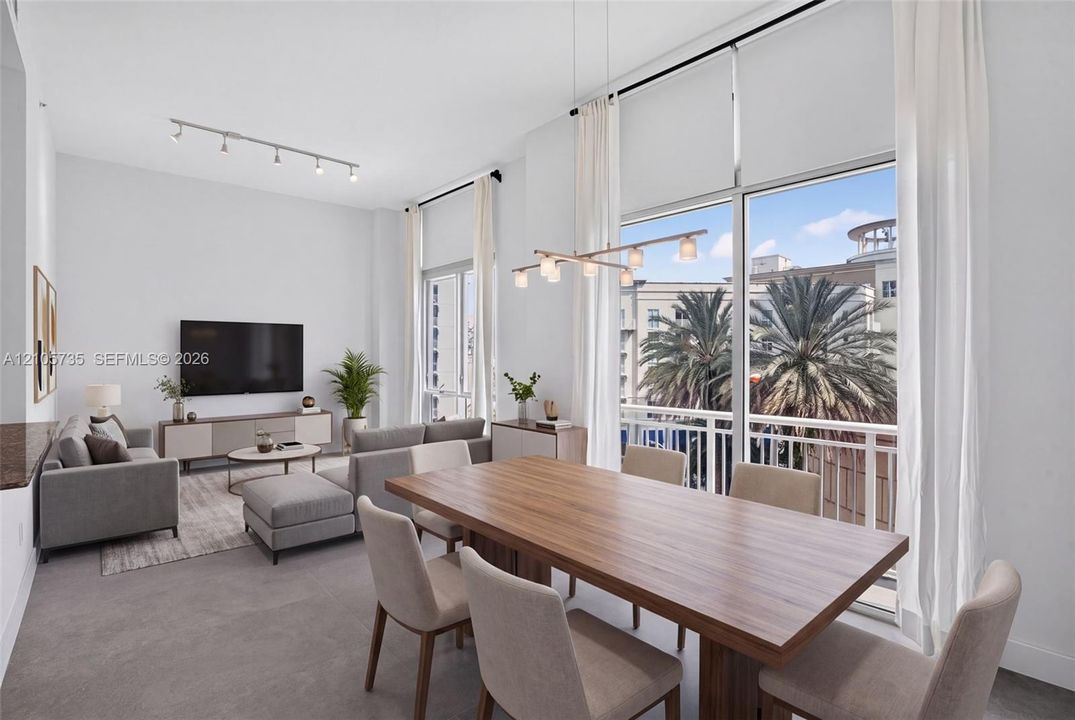 Double-height ceilings, floor-to-ceiling windows, private balcony, linear chandelier, and adjustable track lighting