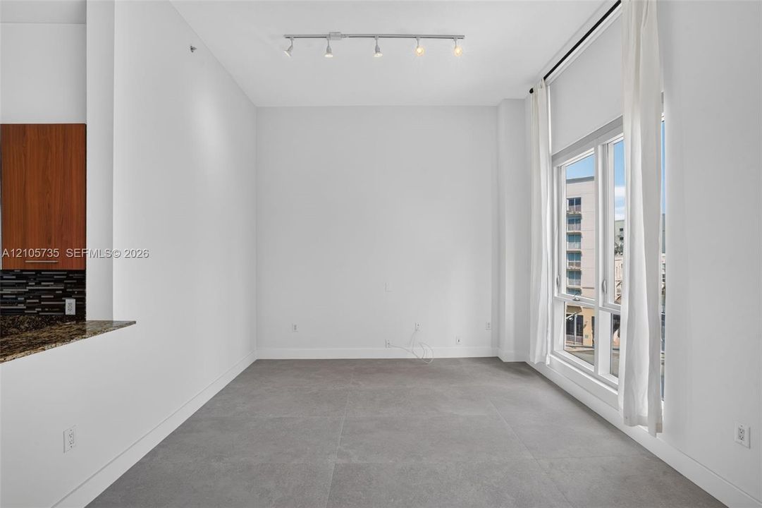 Large-format tile flooring, high ceilings, full-height windows, and adjustable track lighting