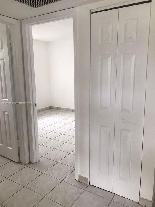 Interior area featuring ceramic tile flooring, a six-panel bi-fold closet door, and a six-panel swinging door