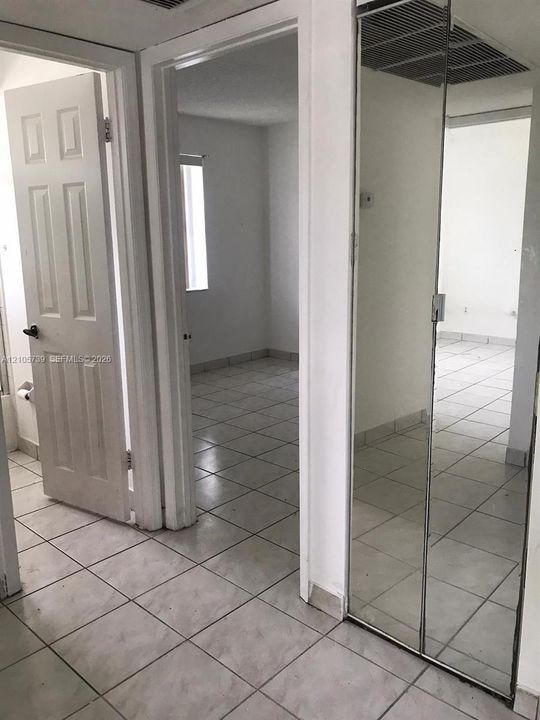 Ceramic tile flooring, full-height mirrored closet doors, and solid-core interior doors