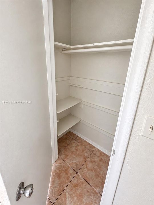 Storage space featuring tile flooring and multi-level built-in shelving