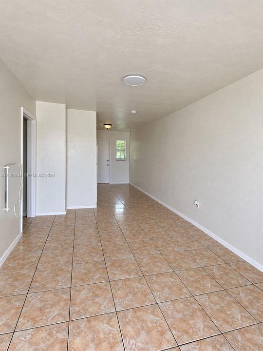 Interior space featuring neutral wall tones, large-format ceramic tile flooring, and flush-mount ceiling lighting