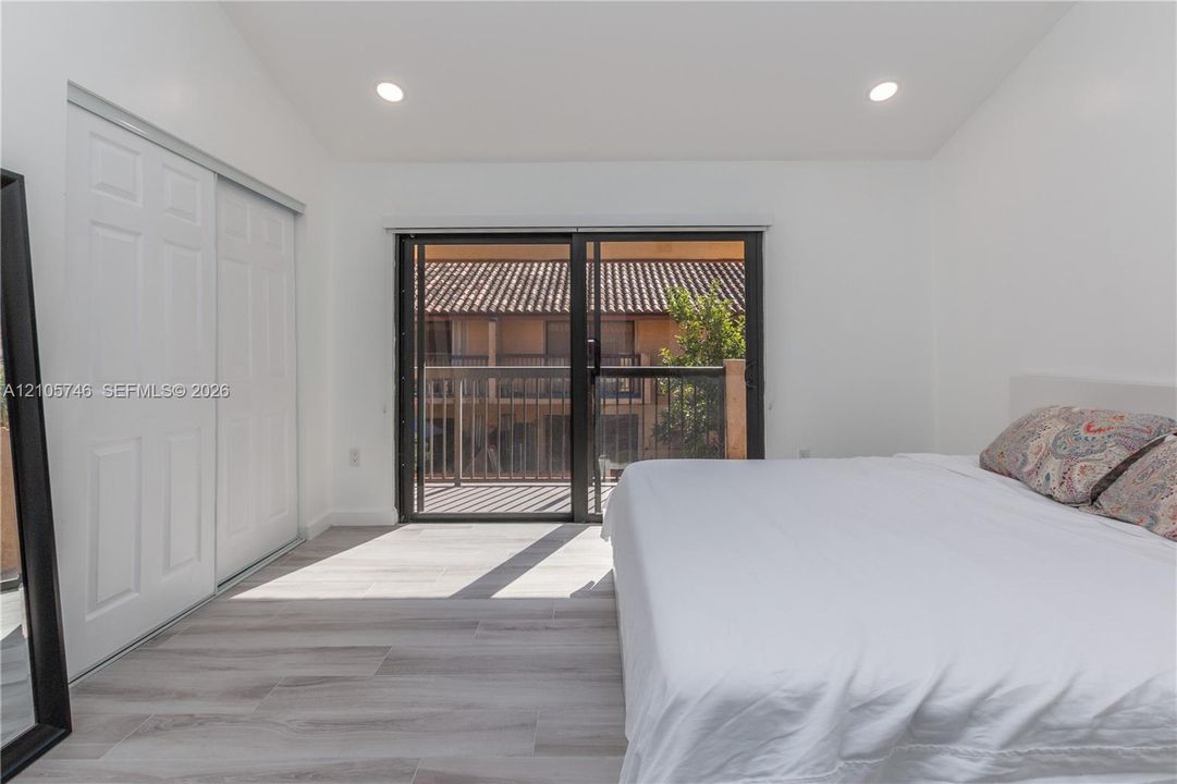Wood-finish flooring, recessed lighting, sliding glass door, and a sliding door closet