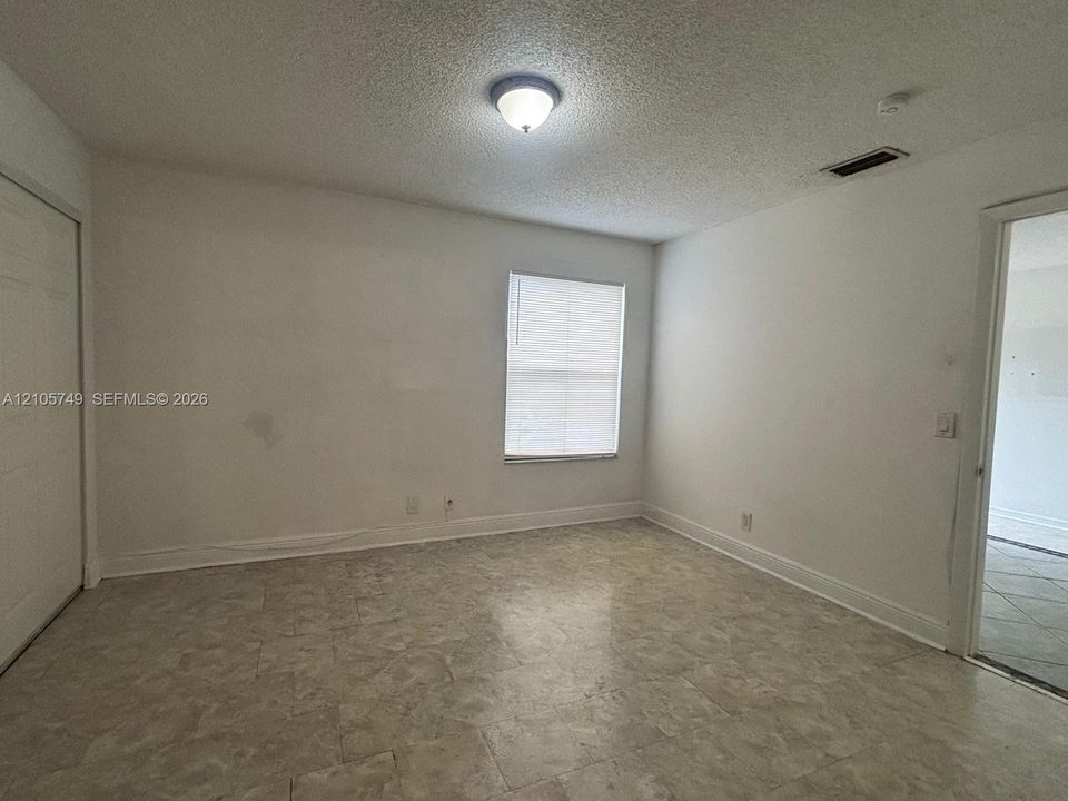 Neutral-toned tile flooring, flush-mount ceiling lighting, and a single-pane window