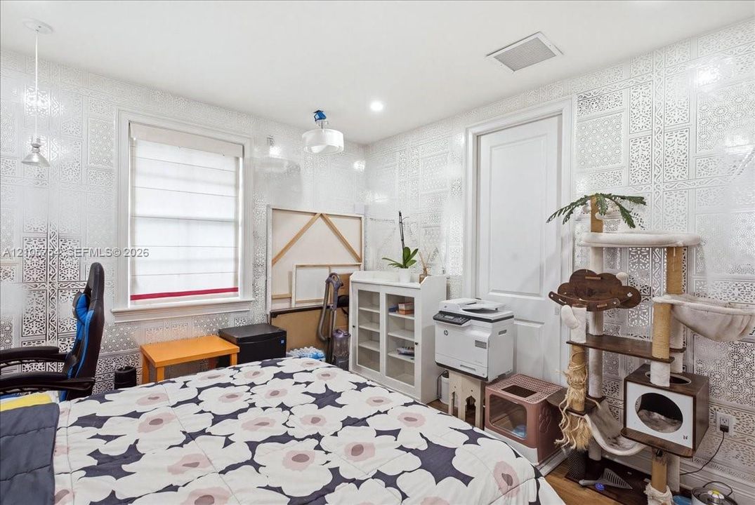 Room featuring patterned wall coverings, a single-hung window with roller shades, recessed lighting, and a pendant light fixture