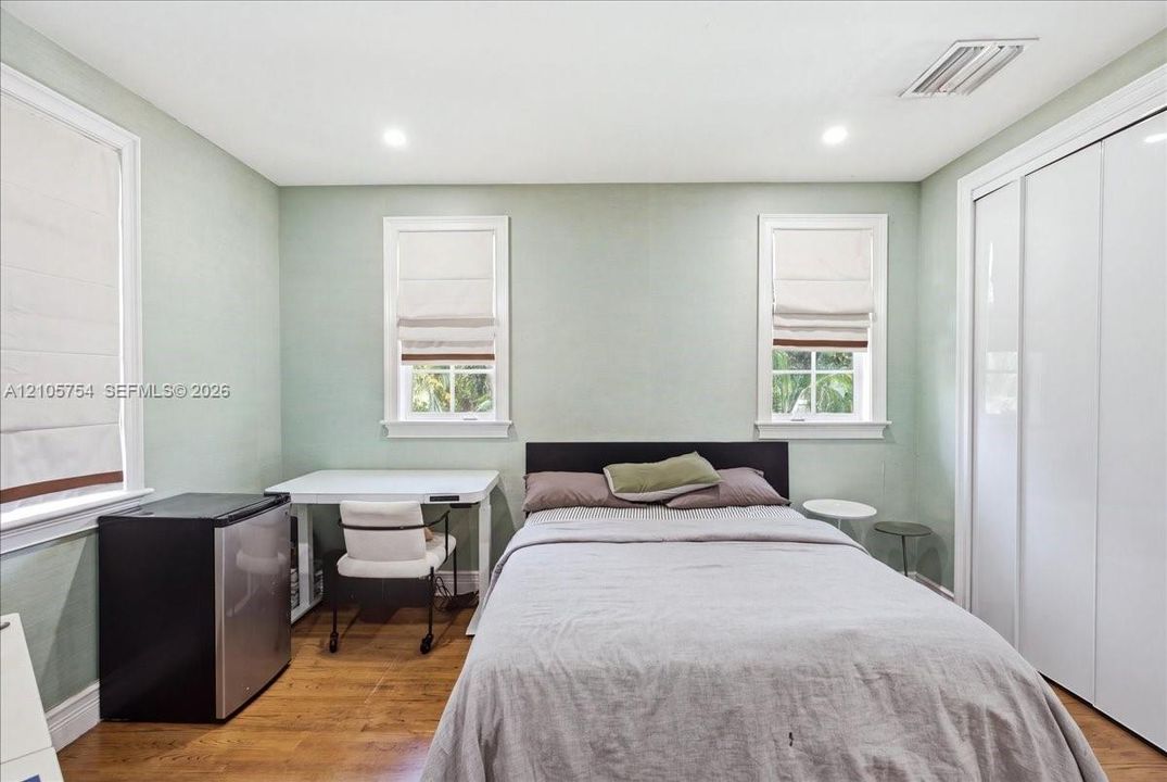 Room featuring wood-finish flooring, recessed lighting, and white sliding-door closet cabinetry