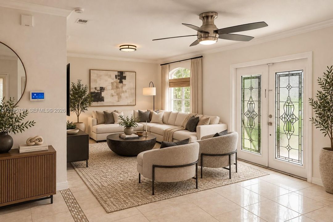 Double entry doors featuring decorative leaded glass inserts, crown molding, brushed metal ceiling fan with integrated lighting, arched window with trim, and polished tile flooring