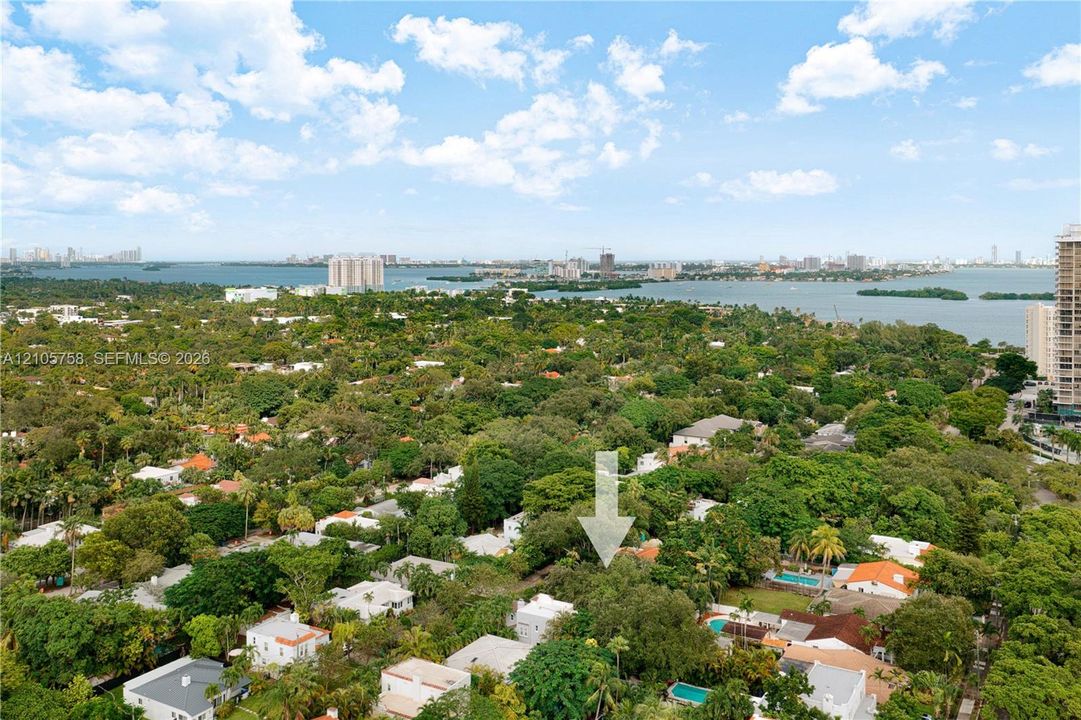 Aerial perspective highlighting a tree-lined residential setting with water access and coastal scenery