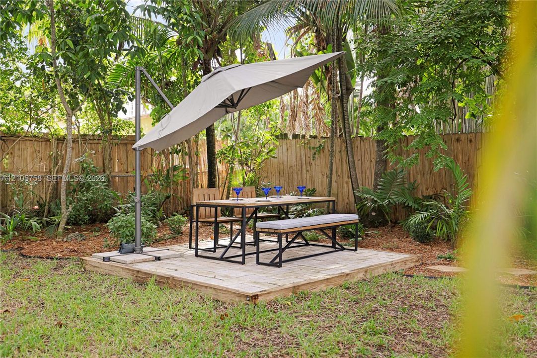 Backyard area featuring a raised wood deck, wood privacy fencing, and established perimeter landscaping