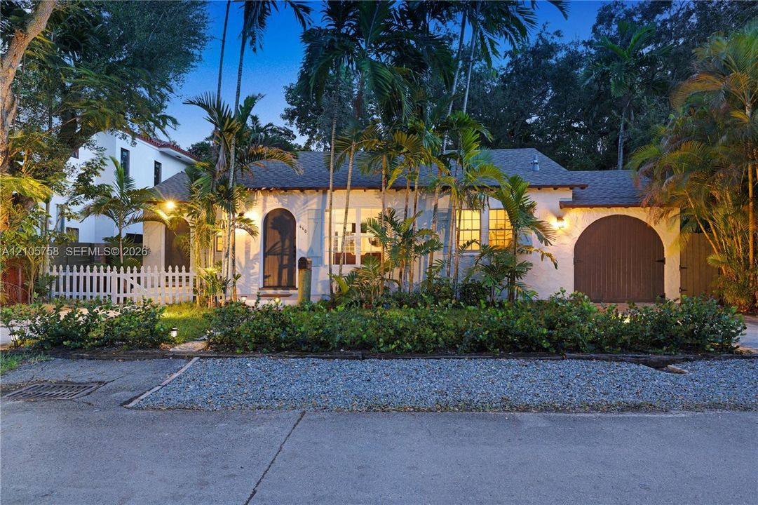 Single-story exterior featuring a textured stucco facade, arched entryway, and an attached rounded garage door