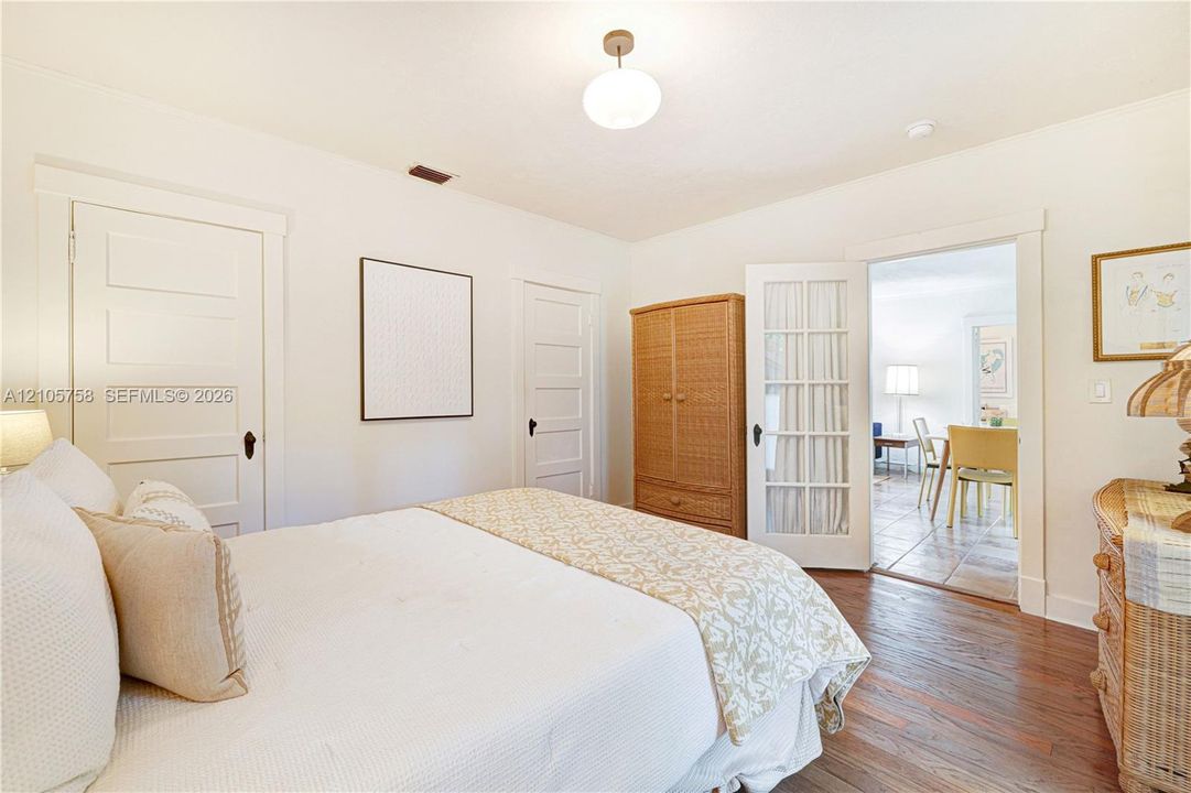 Room featuring wood-finish flooring, white five-panel interior doors, and a glass-paned French door