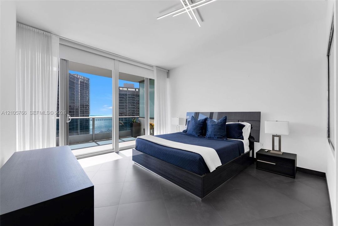 Primary bedroom with sliding doors to the private terrace and bay views.