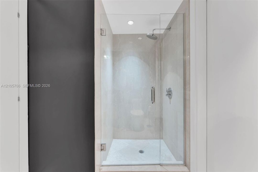 Glass-enclosed walk-in shower with rain shower head in the second bath.