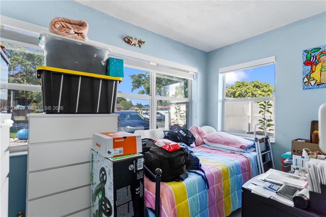 Room featuring multi-pane windows with white framing and roller shades