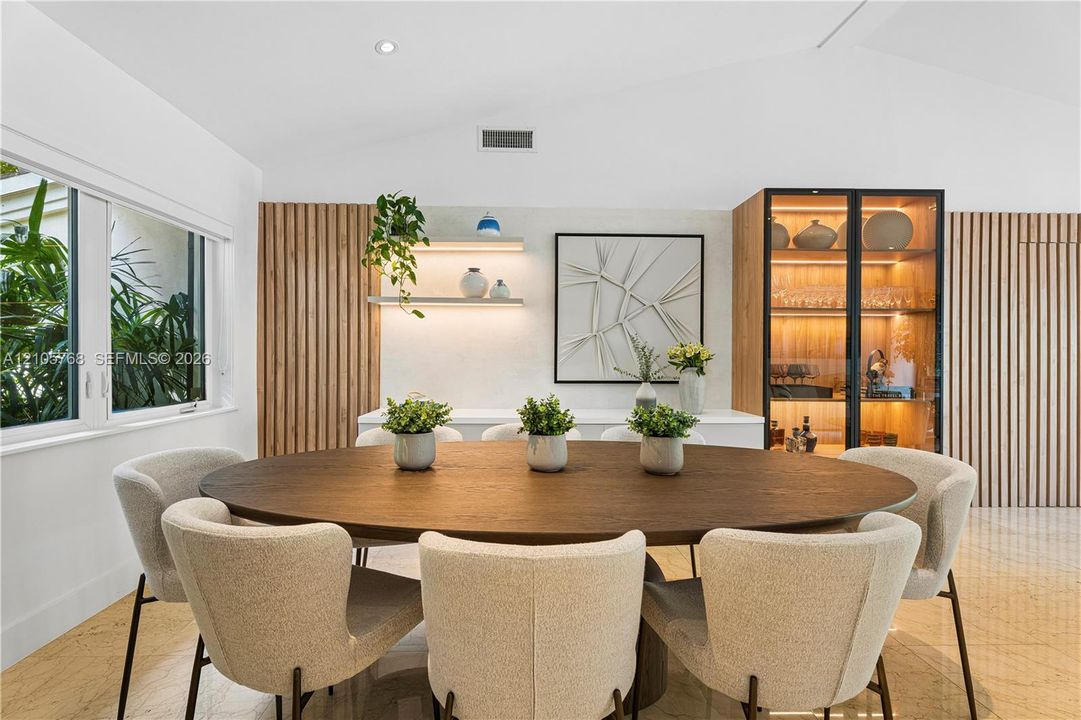 Vaulted ceilings, vertical wood slat wall detailing, integrated display cabinetry with glass shelving, and stone-finish flooring