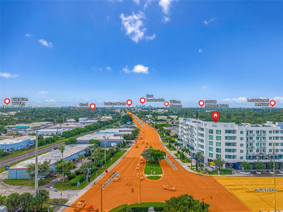 Aerial perspective of a multi-story residential building featuring private balconies, floor-to-ceiling windows, and proximity to major thoroughfares