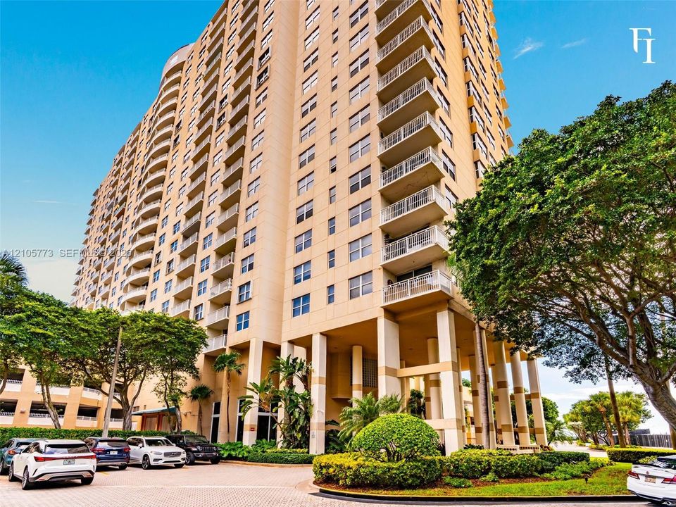 High-rise residential exterior featuring a multi-story facade, private recessed balconies, concrete structural pillars, and landscaped grounds with mature trees