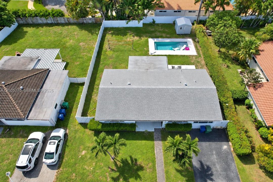 Expansive backyard featuring an inground swimming pool, concrete patio, perimeter privacy fencing, and mature landscaping