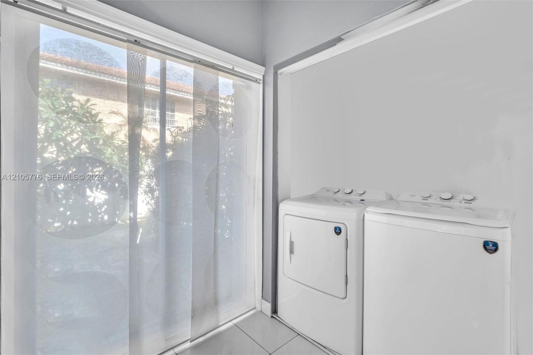 Large sliding glass door with panel tracks and neutral tile flooring