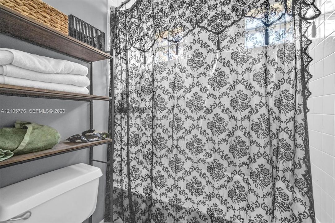 White ceramic tile surround and standard white toilet