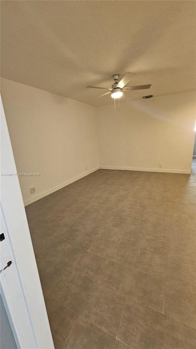 Neutral-toned tile flooring and ceiling fan with integrated lighting