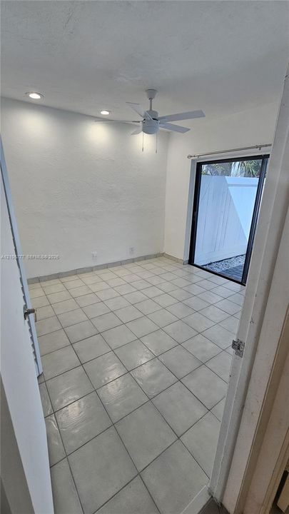 Interior room featuring large-format tile flooring, recessed lighting, a ceiling fan, and a sliding glass door providing external access
