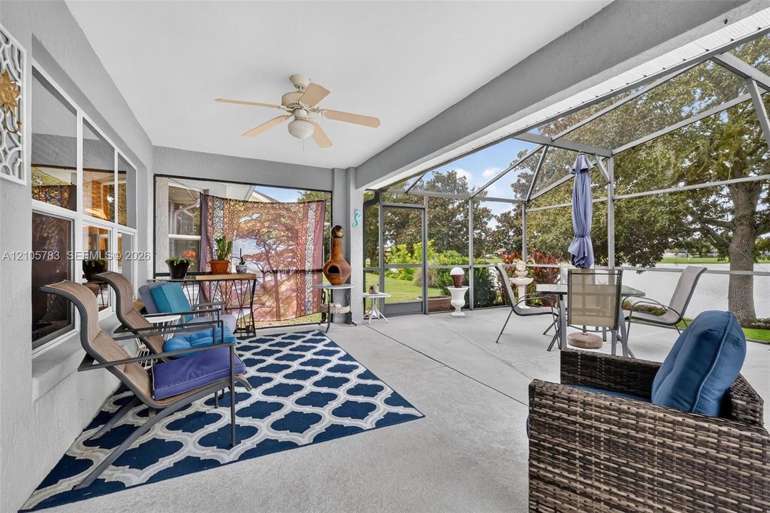Screened-in covered patio featuring a concrete floor and a ceiling fan